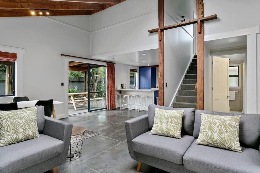 un soggiorno con 2 divani e una scala di Central and Cozy 2BR Retreat With Parking and Free Wifi a Taupo