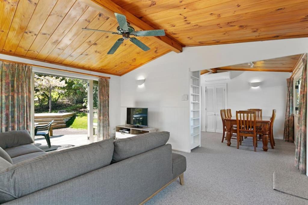 ein Wohnzimmer mit einer Couch und einem Deckenventilator in der Unterkunft Bellbird Cottage With Lake and Mountain Views in Taupo