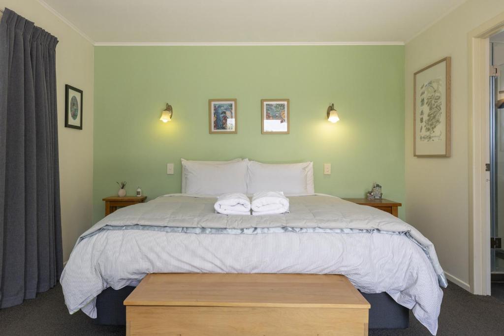a bedroom with a large bed with two towels on it at Fantail Retreat, Family 4BR Near Lake and Gardens in Taupo