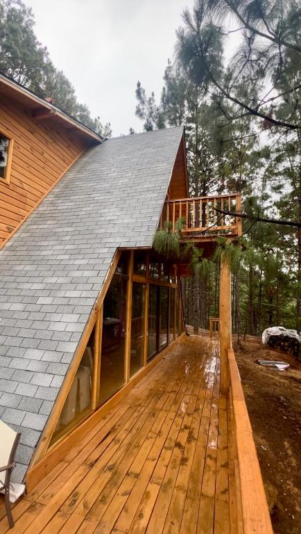 ein Haus mit Metalldach und Terrasse in der Unterkunft Nido de Madera in San Mateo Río Hondo