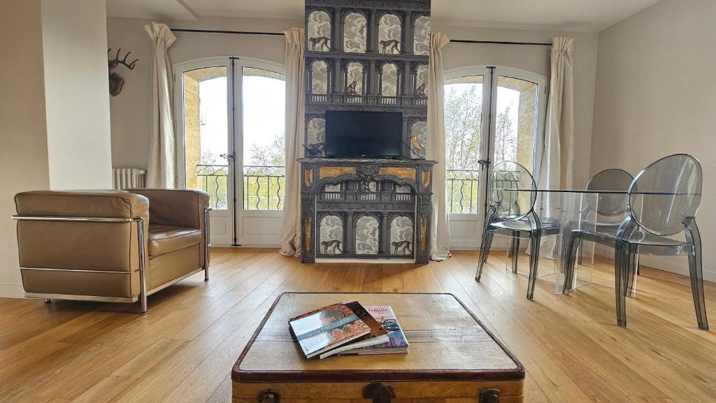 - un salon avec une table, des chaises et une télévision dans l'établissement Grand appartement avec vue sur la fontaine de la Rotonde, à Aix-en-Provence