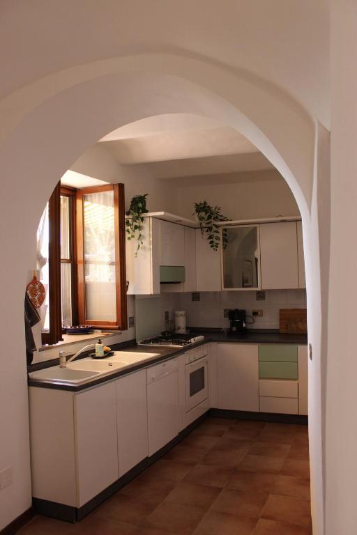 a kitchen with white cabinets and an archway at A BeautifuL Terrace on Paradise Imperia - by HOST4U in Montegrazie