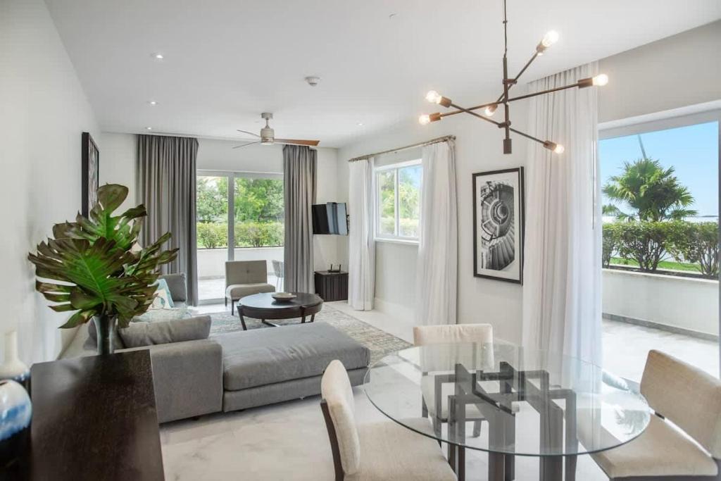 a living room with a couch and a glass table at Garden Villa Condo at ONE Cable Beach in Nassau