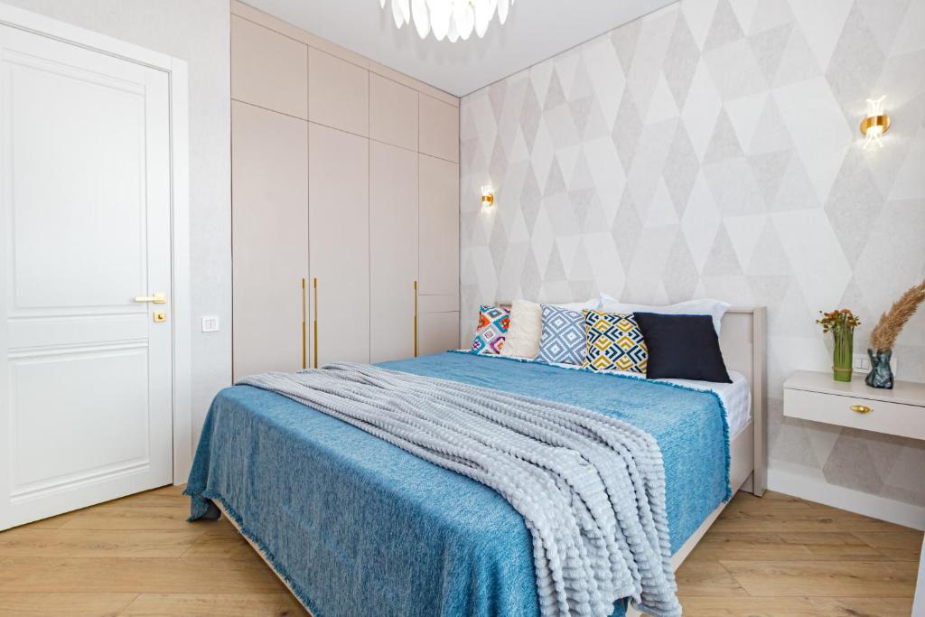 a bedroom with a bed with a blue blanket at Теплый уголок Aruna City in Astana