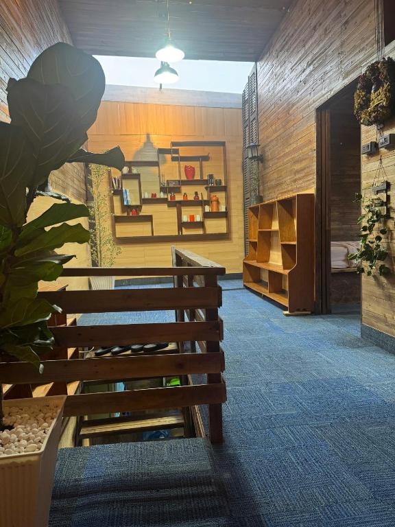 a room with a bench and a table and shelves at Nhà Của Sen in Da Thien