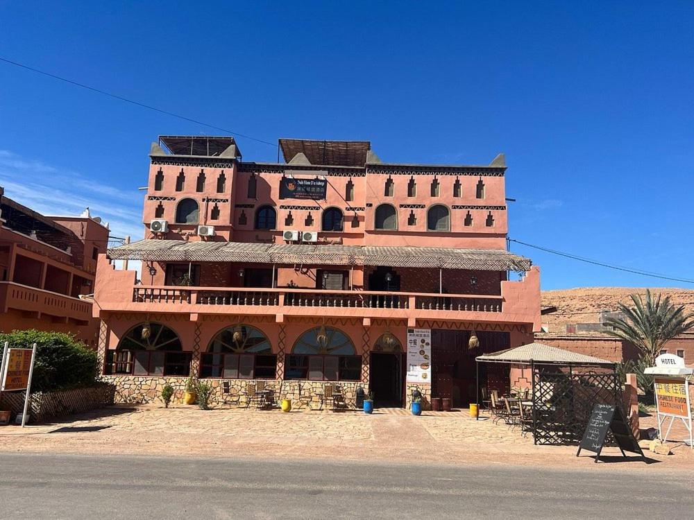 ein großes rotes Backsteingebäude an der Straßenseite in der Unterkunft Auberge Etoile Filante d Or Ait Ben Haddou in Aït-Ben-Haddou