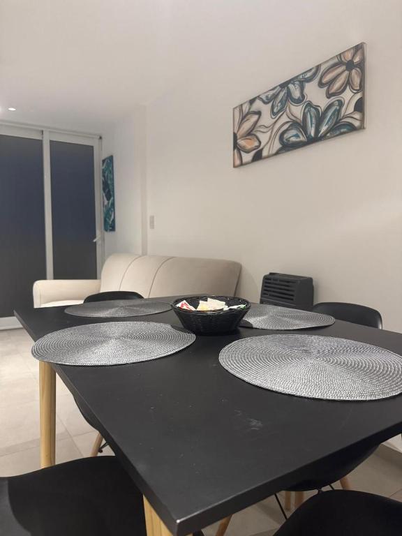 a black table with four chairs and a bowl on it at Alojamientosvillamaria in Villa María