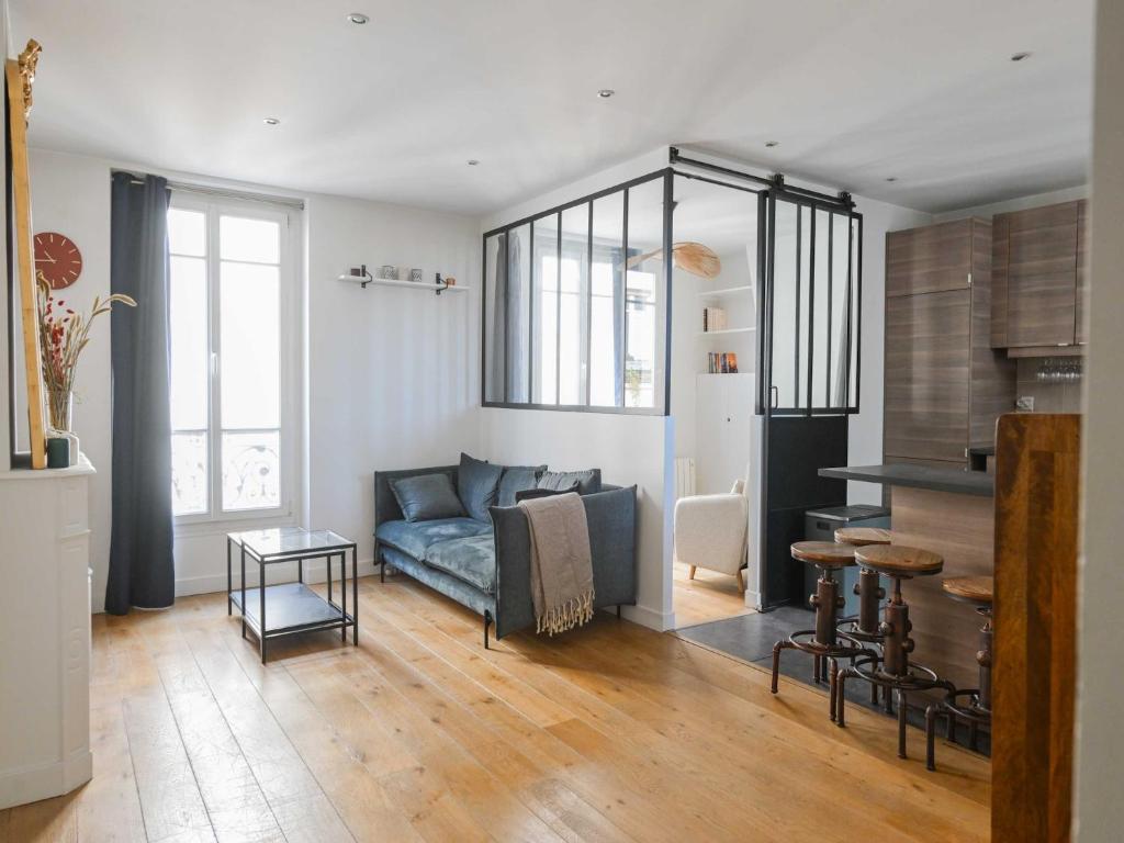 un salon avec un canapé bleu et une table dans l'établissement Modern Apartment - 2BR-4P- Canal Saint-Martin, à Paris