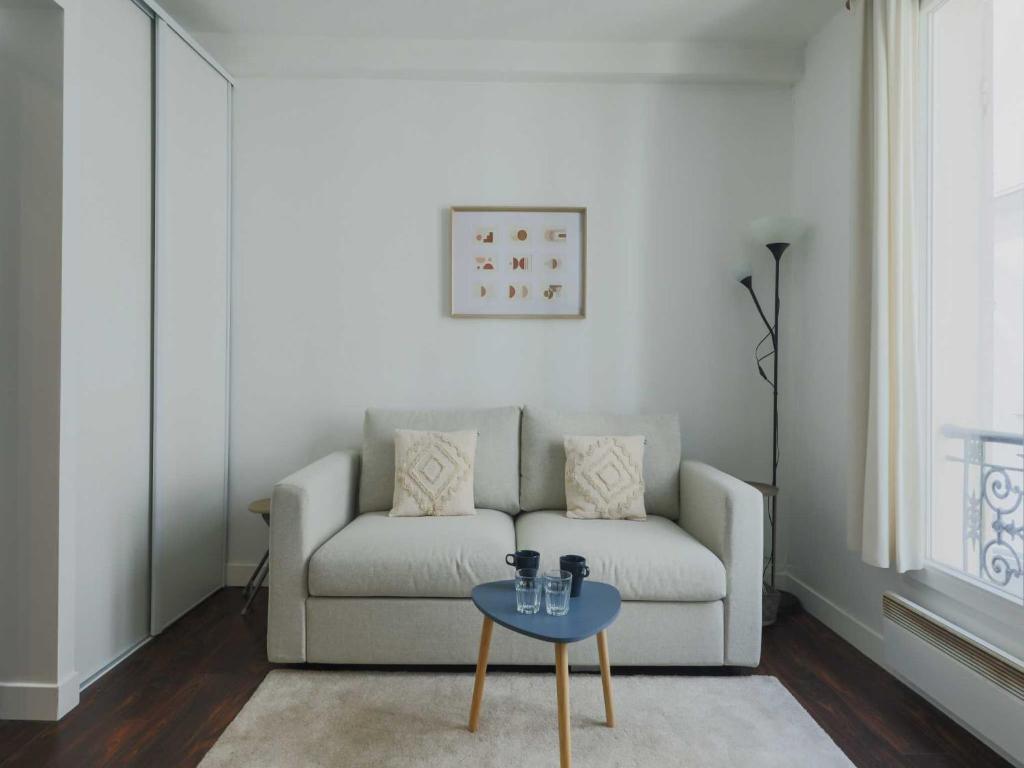 a living room with a couch and a table at Charming studio - 2P- Parc Monceau in Paris