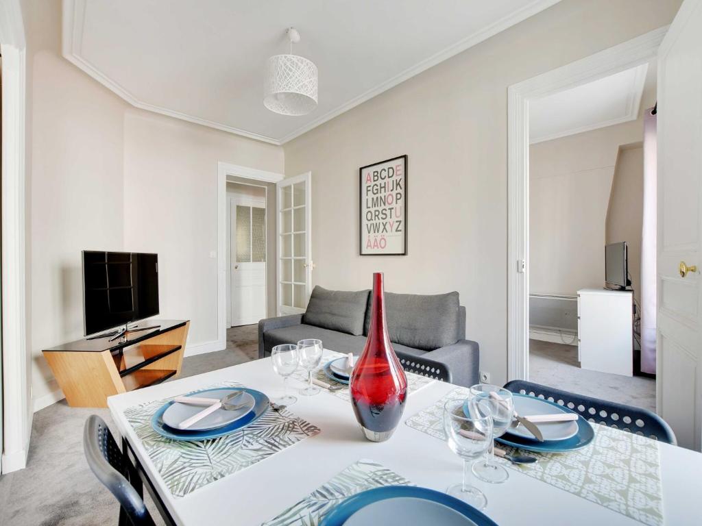 - un salon avec une table et un vase dans l'établissement Bright apartment - 2BR-4P - Belleville, à Paris