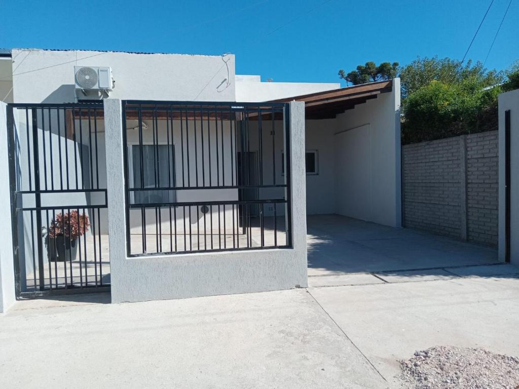 ein Tor zu einem Haus mit einer Garage in der Unterkunft Departamento in Trenque Lauquen