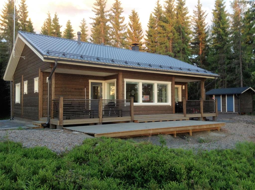 a small cabin with a porch and a solar roof at Ankkuri Raijan Aitta in Mikkeli