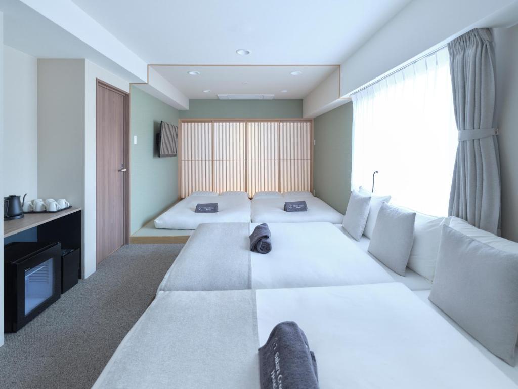 Postel nebo postele na pokoji v ubytování Sakura Cross Hotel Kyoto Kiyomizu