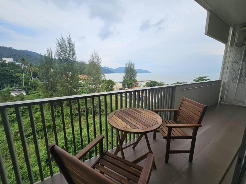 a table and chairs on a balcony with a view of the ocean at By The Sea with Side Seaview n Sunset view #3A2 in Batu Ferringhi