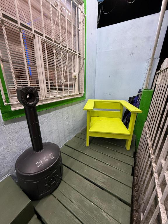 a yellow bench and a stove on a porch at OQP Vacations in Miami