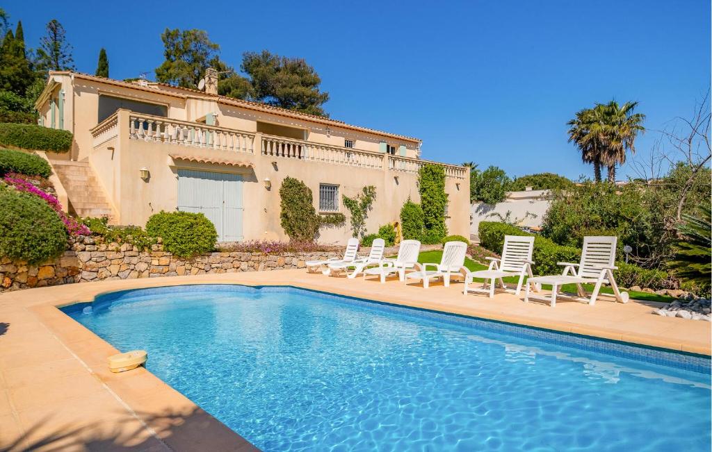 une villa avec une piscine entourée de chaises et une maison dans l'établissement Pet Friendly Home In Saint Aygulf, à Saint-Aygulf