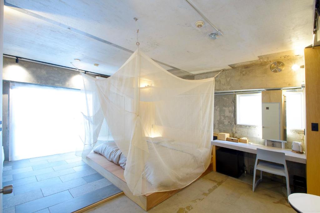 福岡市にあるウクネ Hotel UKUNEのベッドルーム(蚊帳付きのベッド付)