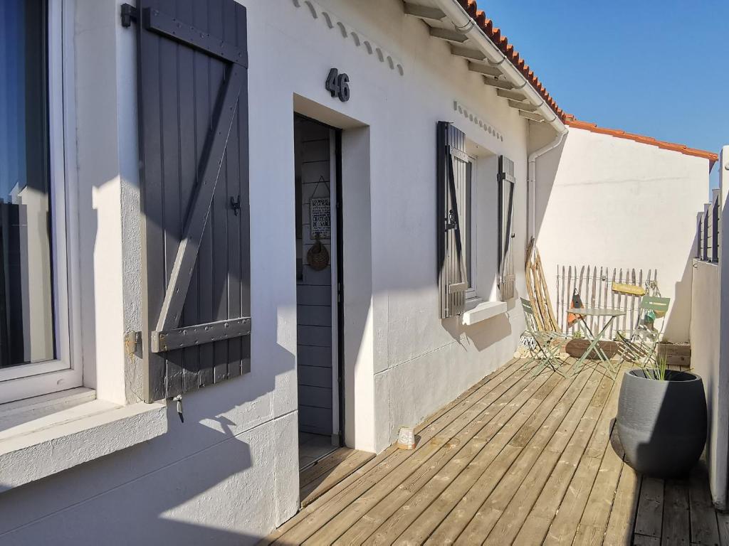 a house with a wooden porch with a door at Maison rénovée, animaux admis, proche plage et centre-ville - FR-1-194-296 in La Tranche-sur-Mer