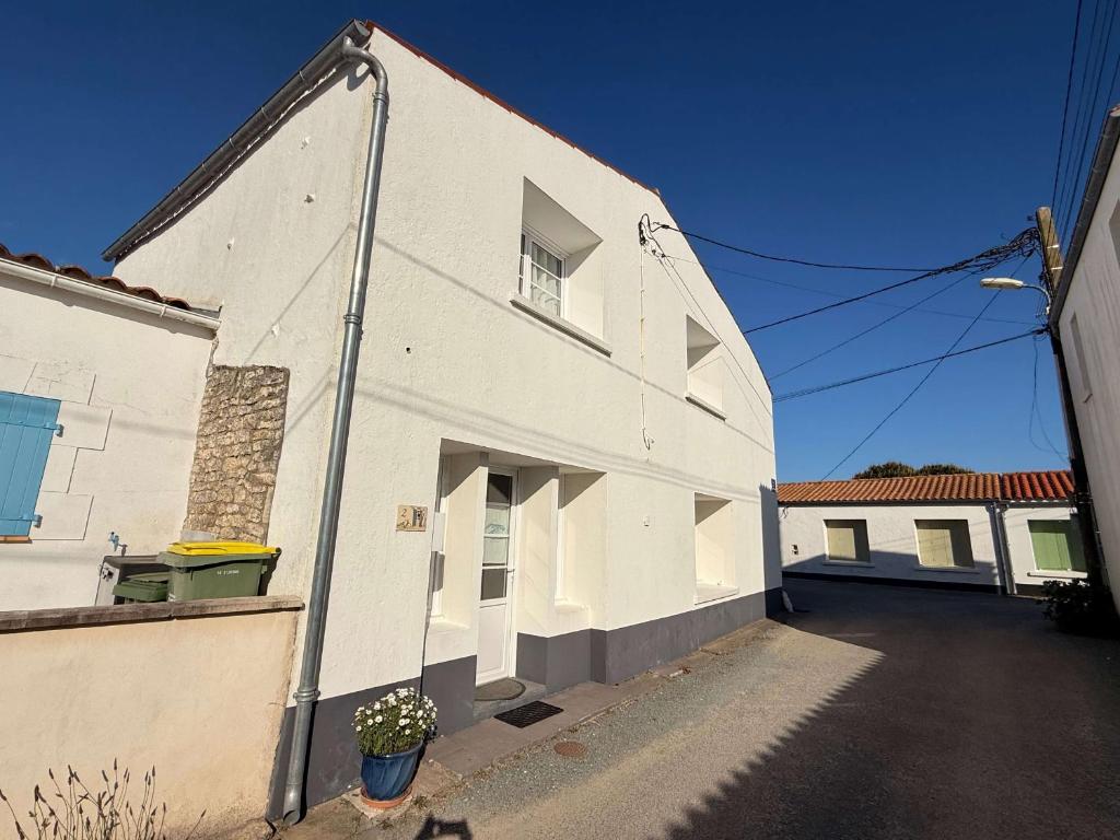 un bâtiment blanc avec une fenêtre sur le côté dans l'établissement Charmante maison de village à Saint-Pierre-d'Oléron, idéale pour 4 personnes - FR-1-778-52, à Saint-Pierre-dʼOléron