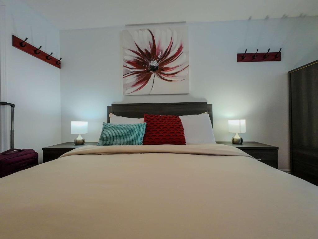 a bedroom with a large white bed with two lamps at Logis des Prodiges - Le 773 in Rouyn-Noranda