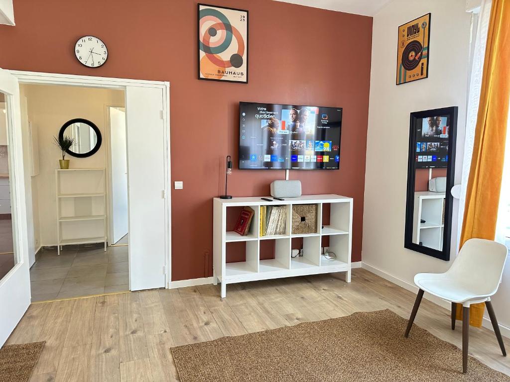 a living room with a tv on a wall at Elegant 2 Bedroom Apartment with Free Parking Paris St-Denis by Immo Kit BNB in Saint-Denis