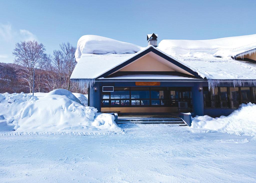 una casa cubierta de nieve con un montón de nieve en Berjaya Hakkoda Ski Resort, en Aomori