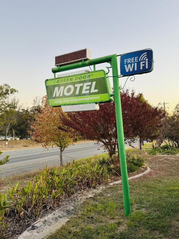 a sign for a motel on the side of a road at Green Door Motel in Albury