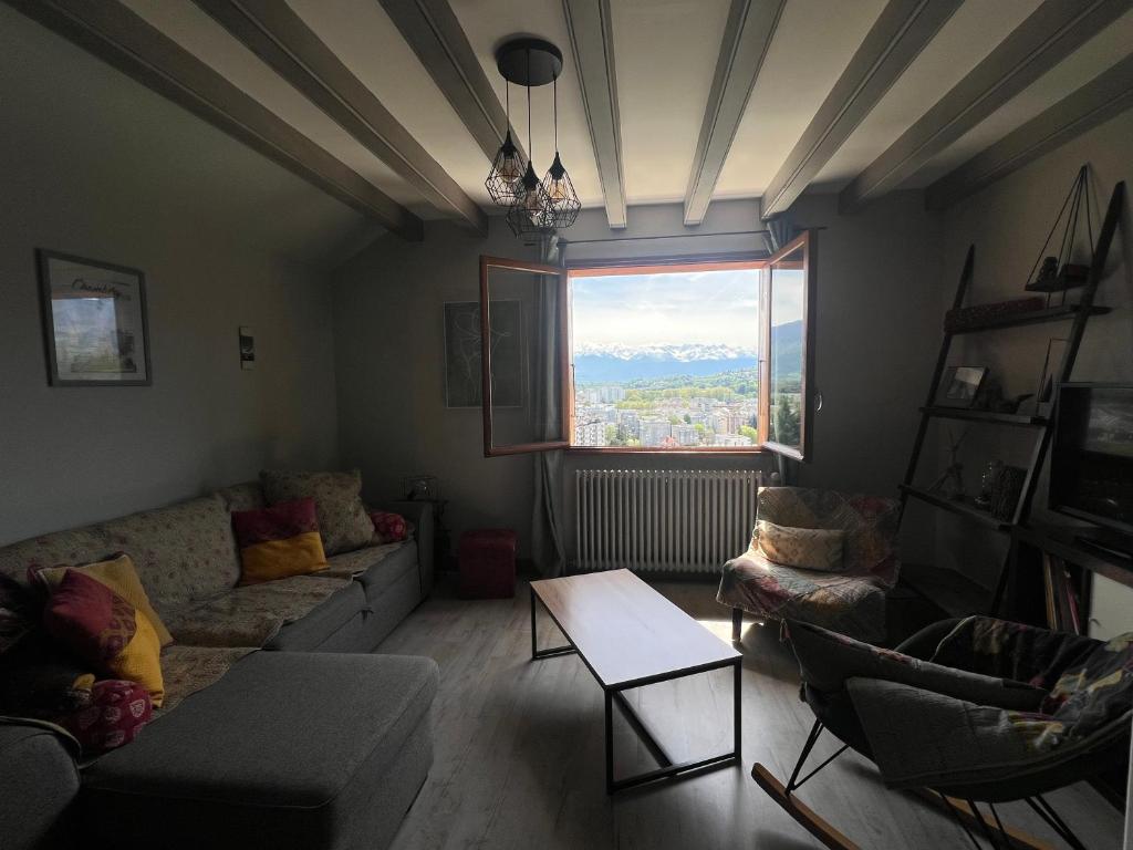 un salon avec un canapé, des chaises et une fenêtre dans l'établissement Reflets de montagnes, à Chambéry