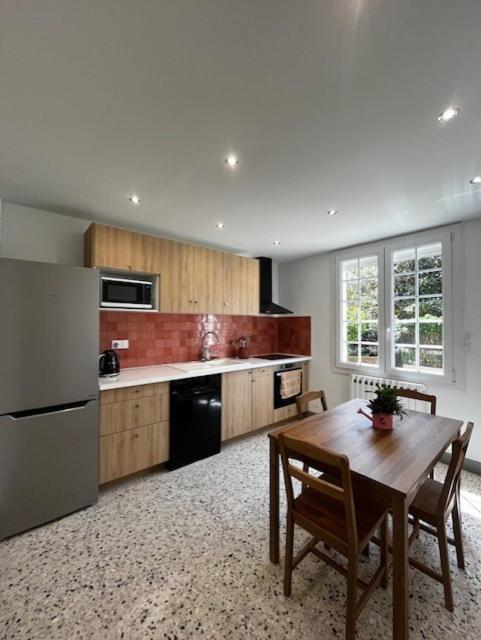 une cuisine avec une table en bois et un réfrigérateur dans l'établissement Charmant appartement rénové, à 15 mn d'Avignon et de son festival, à Entraigues-sur-la-Sorgue