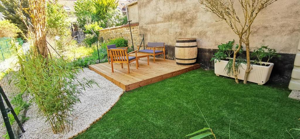 une petite cour arrière avec une terrasse en bois avec un banc dans l'établissement Quai des Ducs, à Dijon