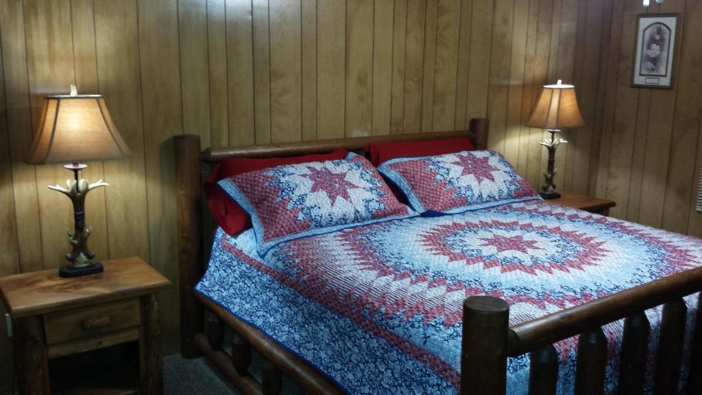 a bedroom with a bed with pillows and two lamps at Two Rivers Lodge in Bryson City