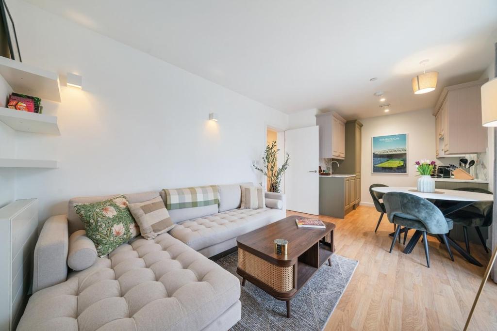 ein Wohnzimmer mit einer Couch und einem Tisch in der Unterkunft Modern and central 1BR Flat with Skyline View in London