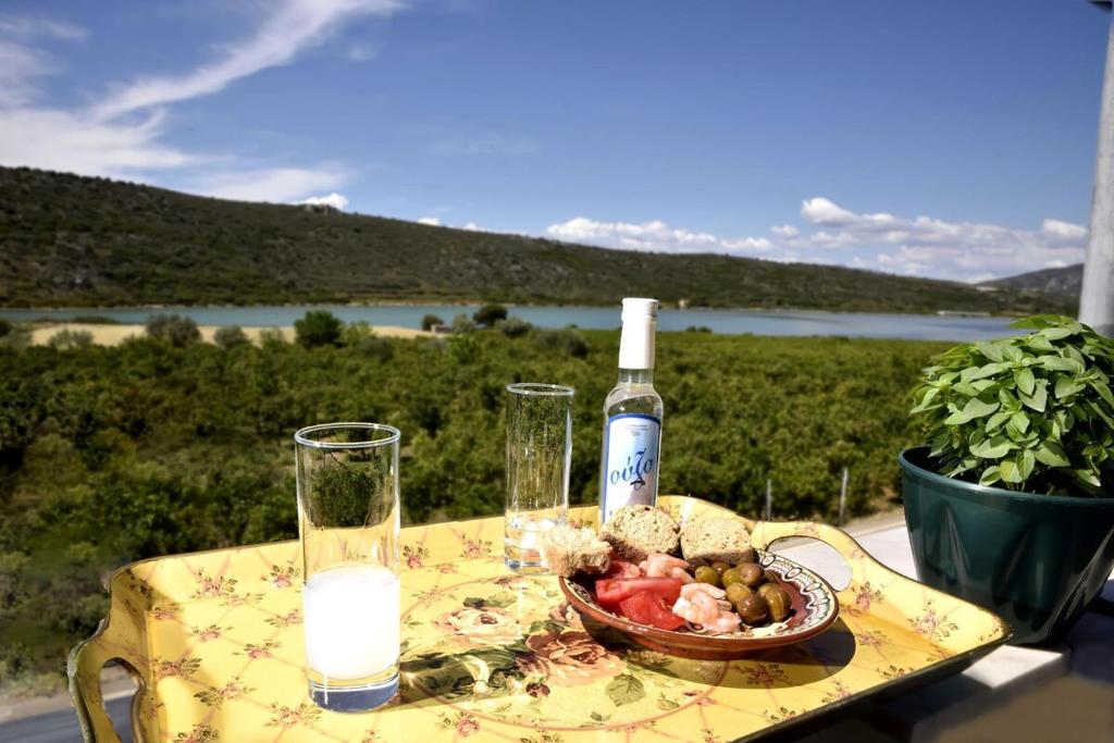 una mesa con una botella de vino y un bol de fruta en Mailia Lagoon, en Vivari