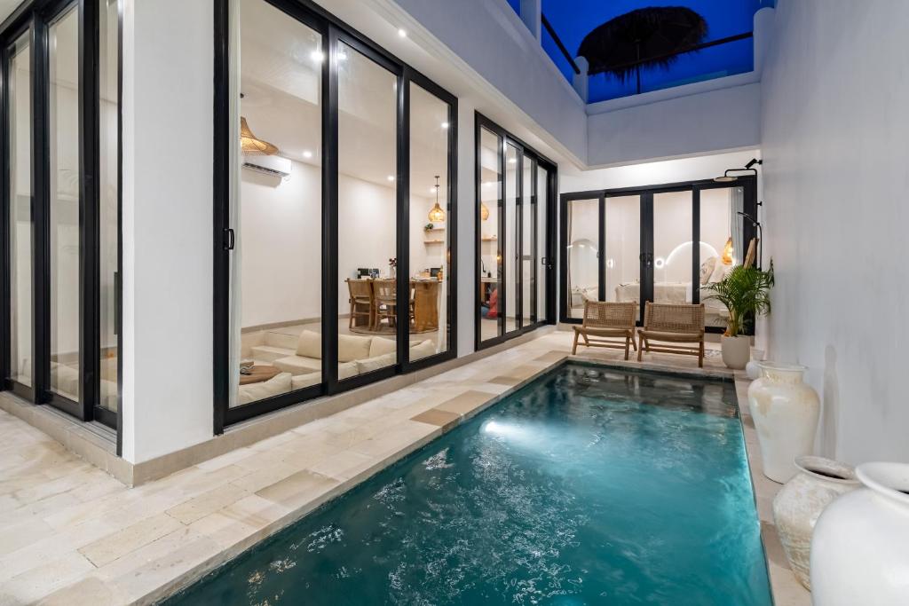 an indoor pool in a house with glass windows at Villa Casamo in Bali in Badung