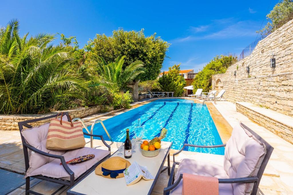 a villa with a swimming pool with a table and chairs at Villa Anta in Astérion