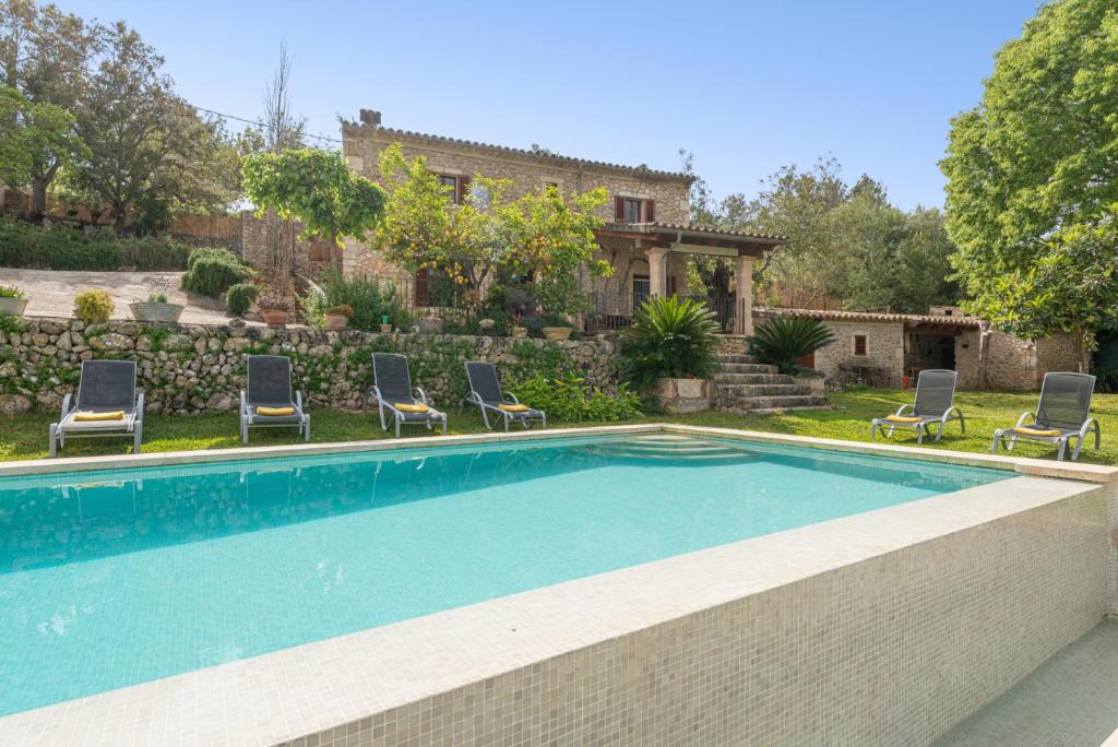 a swimming pool with chairs and a house at Pou Bo - Campanet in Campanet