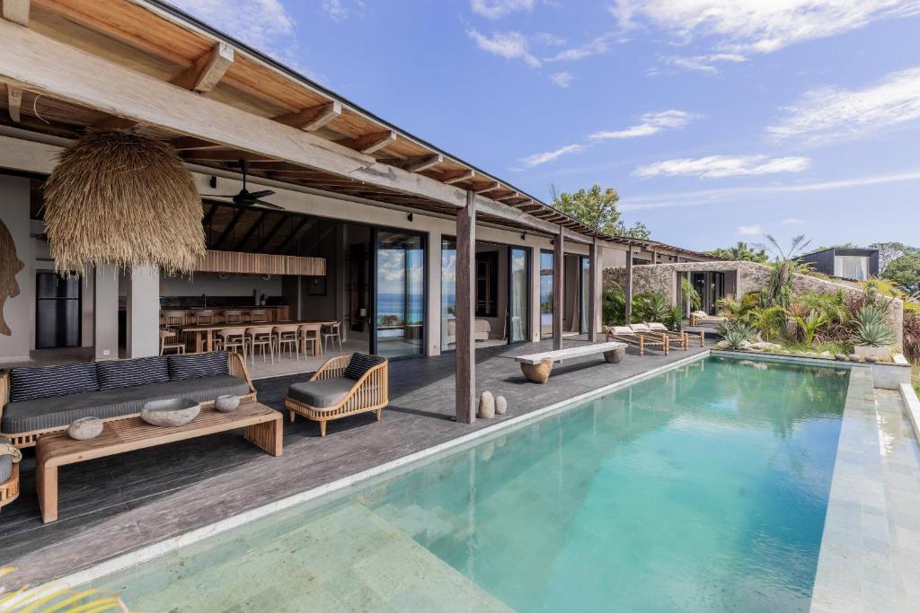 une terrasse avec une piscine et une maison dans l'établissement Panorama Villas Ceningan, à Nusa Lembongan
