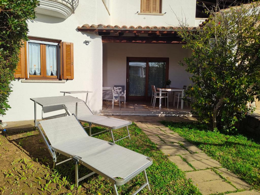 a patio with two chairs and a table in front of a house at Apartment with garden in Budoni