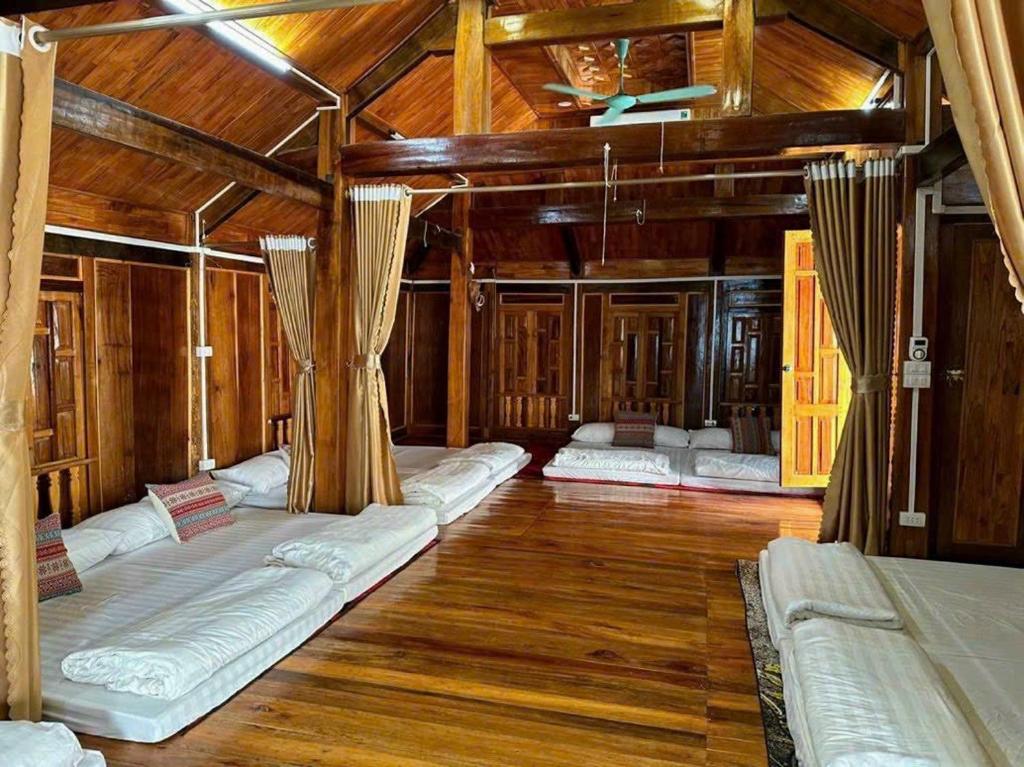 Zimmer mit mehreren Betten und Holzdecken in der Unterkunft Bông Cải Xanh Homestay in Mai Châu