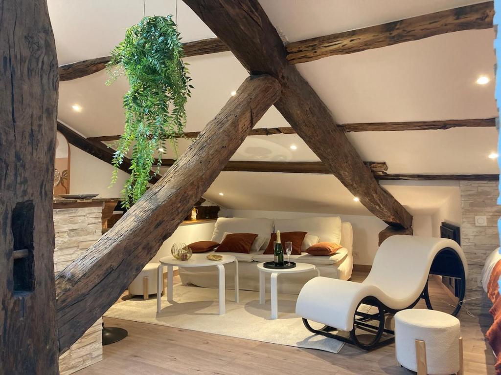 a living room with wooden ceilings and white furniture at Escapade Romantique & Balnéo in Riom