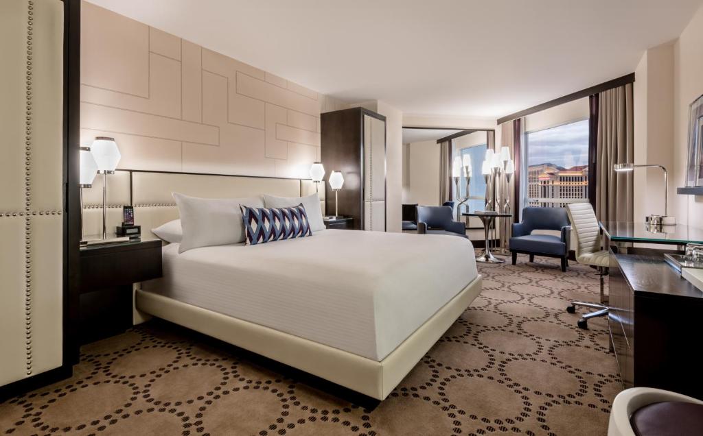 a hotel room with a bed and a desk at Harrah's Las Vegas Hotel & Casino in Las Vegas