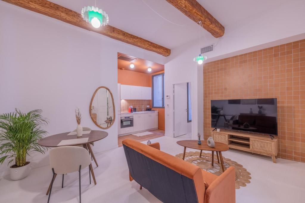 a living room with a couch and tables and a tv at Appartement Belle Lettre 5 in Aix-en-Provence