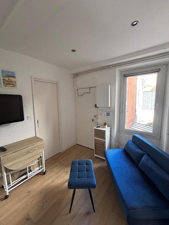un salon avec un canapé bleu et une table dans l'établissement Charmant 2 pièces sur le port avec parking gratuit et WIFI, à Sanary-sur-Mer