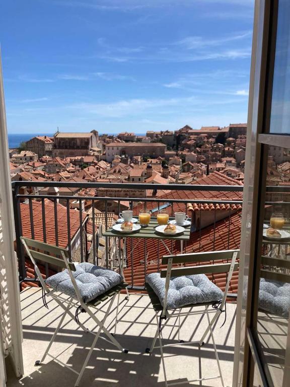a table and chairs on a balcony with a view at Whispering Views House Old Town in Dubrovnik