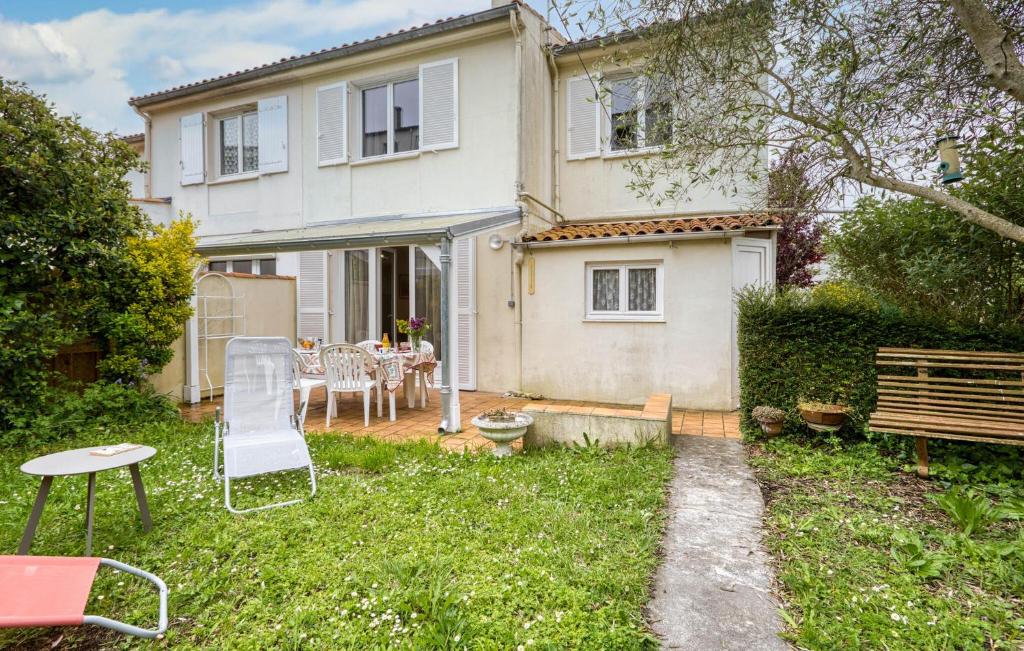 a house with a yard with a table and chairs at 3 Bedroom Awesome Home In Lagord in Lagord