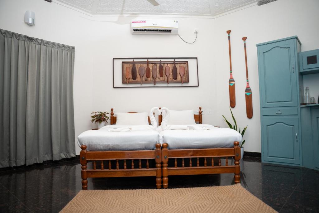a bedroom with a bed and a blue cabinet at Paddle Cult Surf & Yoga in Varkala