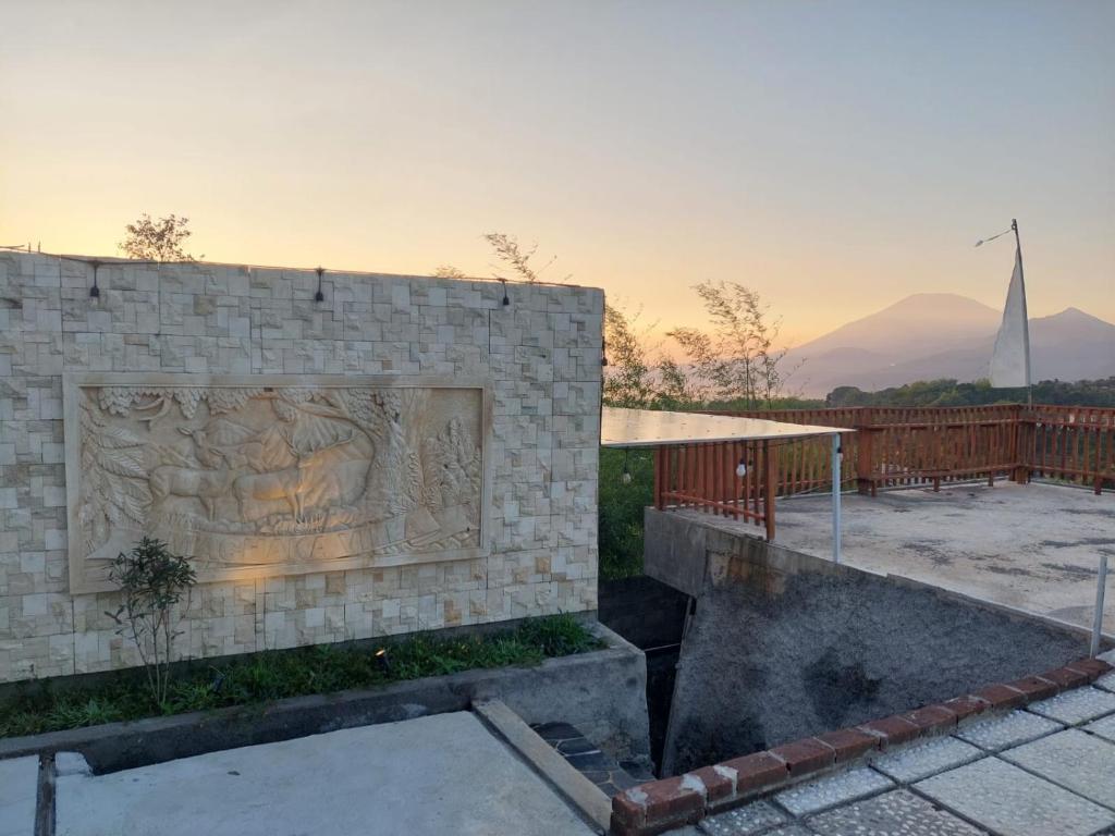 a stone wall with a statue on the side of it at Channel Stay at Machaka Villa Bandungan in Bandungan