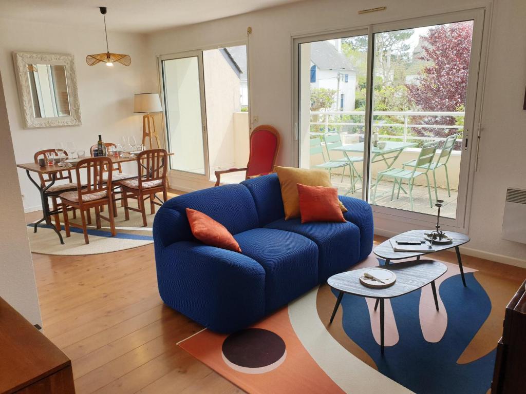 un salon avec un canapé bleu et une table dans l'établissement DRUIDES 2 - Appartement Carnac-Plage - T85, à Carnac