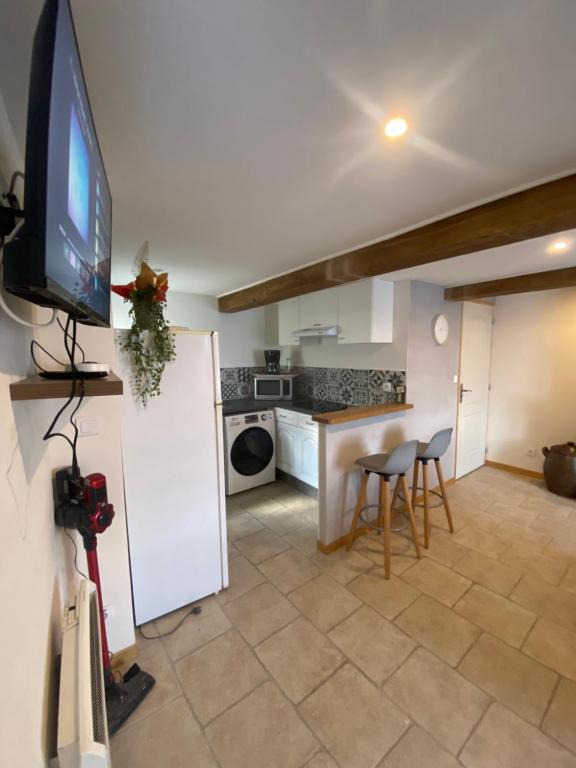 a living room with a tv and a kitchen at Maison de campagne in Ribeaucourt