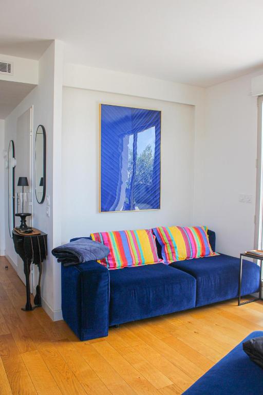 - un canapé bleu avec des oreillers colorés dans le salon dans l'établissement Spacious Duplex with Terrace City Center, à Aix-en-Provence